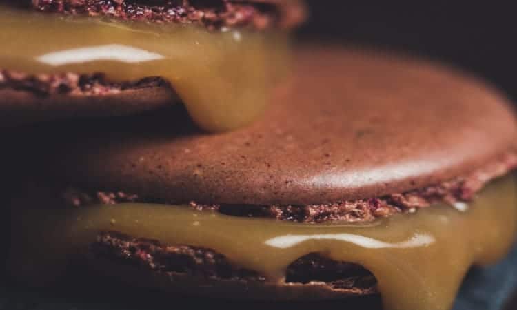 Closeup of two chocolate wafers with sticky caramel in the middle that would be harmful to a new dental crown