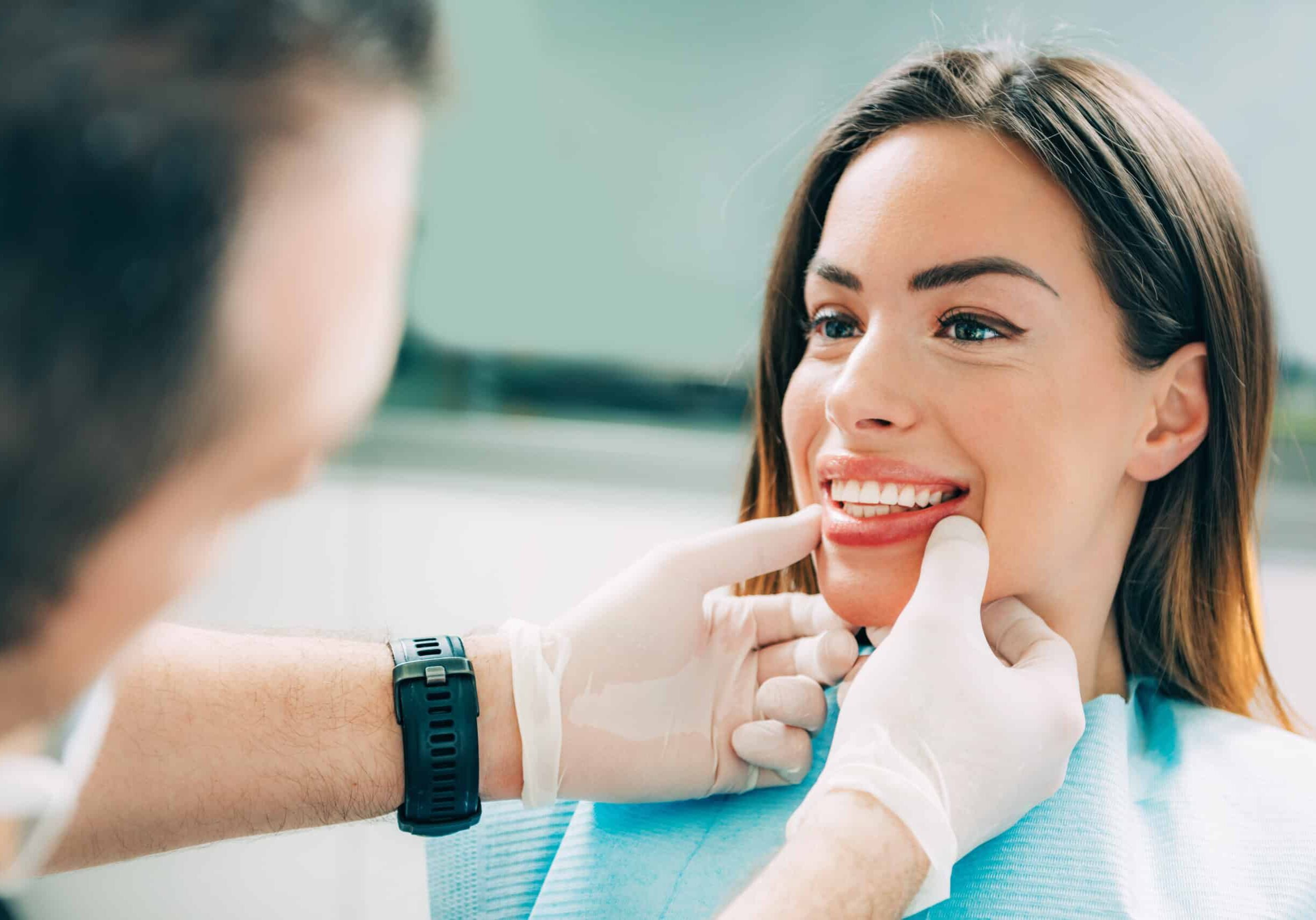 Dentist with beautiful female patient Young smiling woman with beautifiul teeth, having a dental inspection